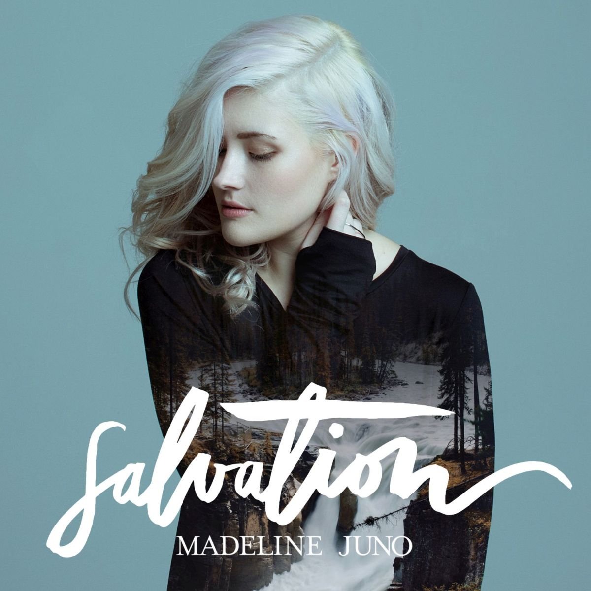 Madeline Juno mit hellblondem Haar vor bläulichem Hintergrund; ihr Pullover zeigt ein überlagertes Naturmotiv mit Fluss und Bäumen – Cover des Albums Salvation