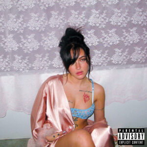 Cil sitzt in Satin gekleidet vor einem Spitzenvorhang und blickt mit ernster Miene in die Kamera – EP-Cover „don’t hold me accountable“.
