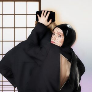 Zwei verschmolzene Figuren in futuristischen Outfits, Blick durch Netzschleier, inspiriert von Alison Goldfrapps „Reverberotic“-Artwork.