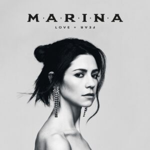 MARINA auf dem Cover von „LOVE + FEAR“ – in Schwarz-Weiß, mit ernstem Blick und schimmernden Ohrringen, radikal reduziert inszeniert.