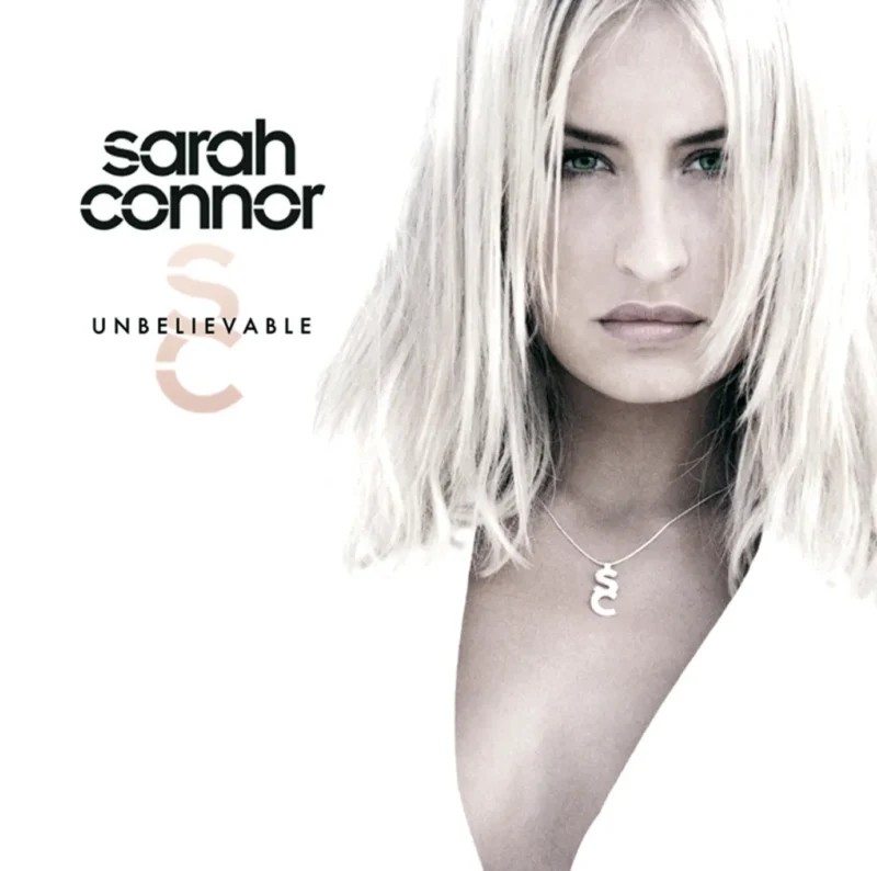Sarah Connor mit ernstem Blick auf dem Cover von „Unbelievable“, schwarz-weiß inszeniert mit SC-Kette.