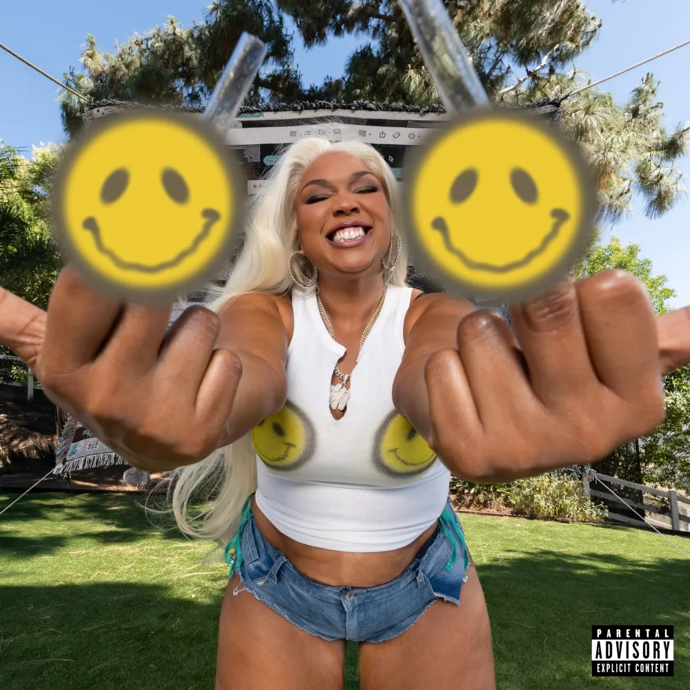 Lizzo steht grinsend im Garten, zeigt beide Mittelfinger mit gelben Smileys – das Mixtape-Cover zu My Face Hurts From Smiling