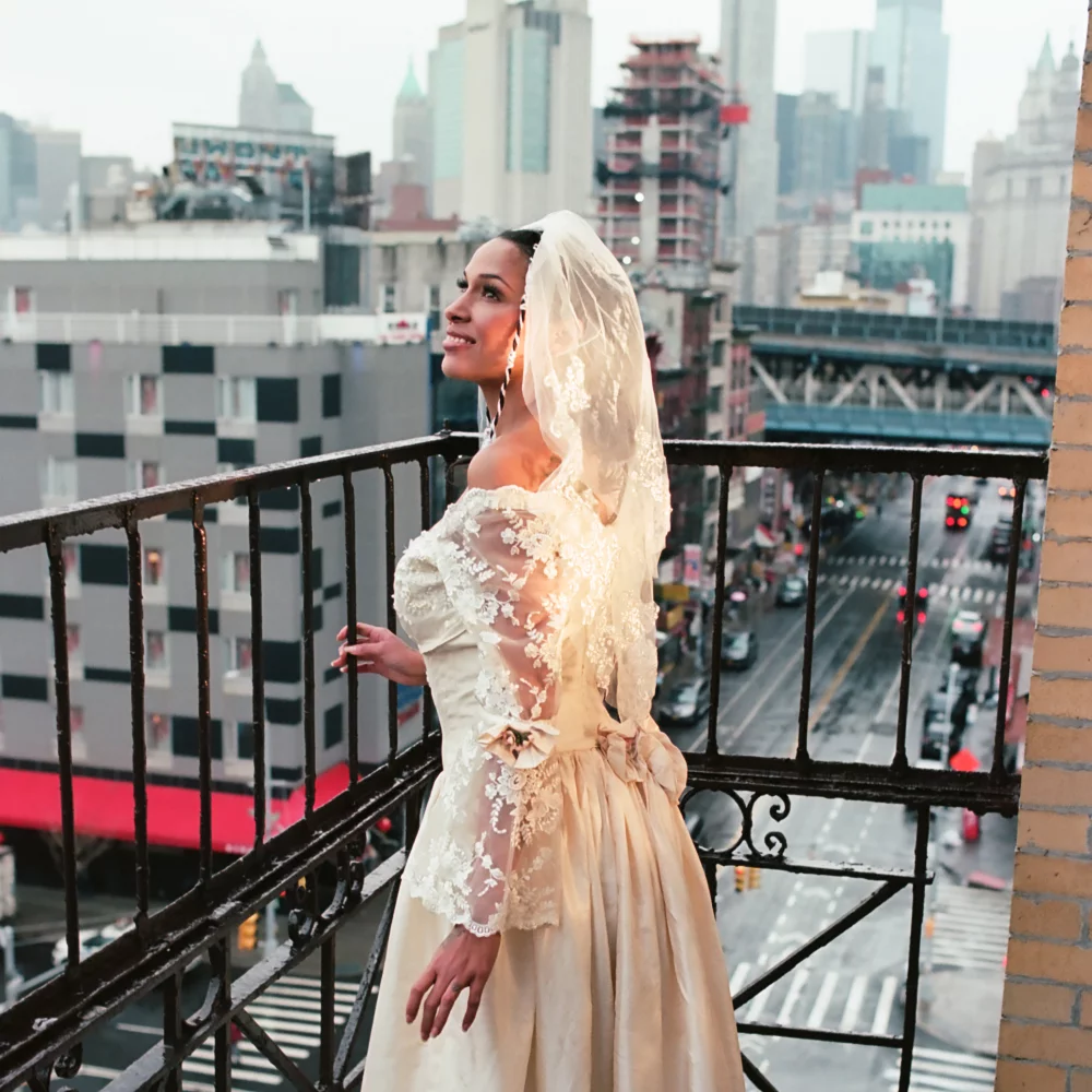 Princess Nokia im Vintage-Brautkleid auf einem New Yorker Balkon – Szene aus dem „Happy“-Musikvideo zur EP „i love you but this is goodbye“.