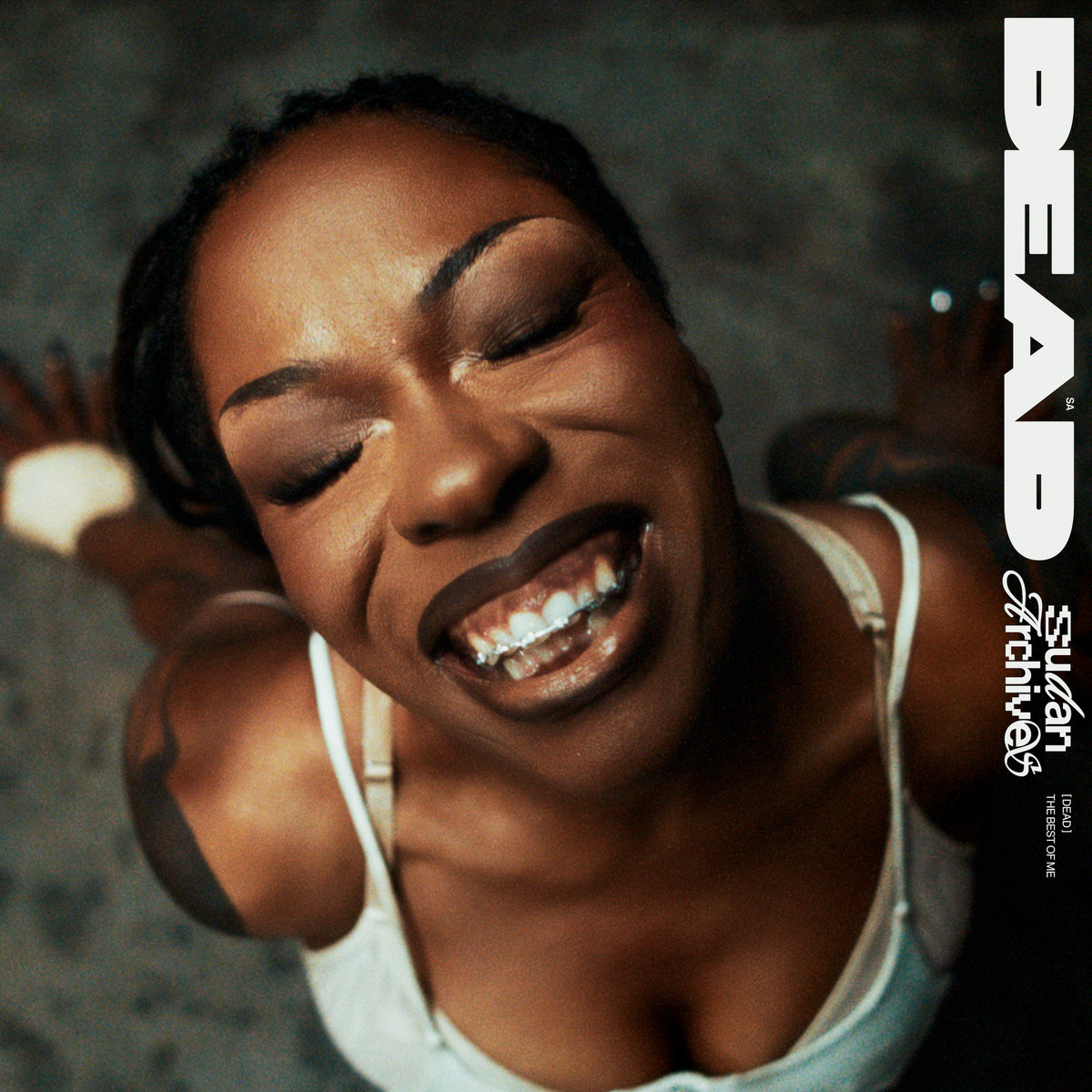 Sudan Archives lacht frontal in die Kamera mit geschlossenen Augen, kraftvoll und befreit – das Cover zur Single „DEAD“.
