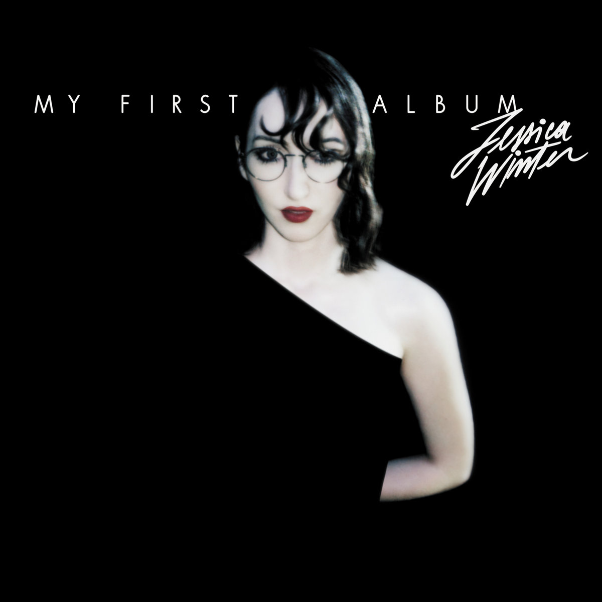 Jessica Winter in tintenschwarzer Kulisse mit asymmetrischem Top – Albumcover von „My First Album“