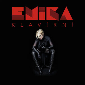 Albumcover von Emika – Klavírní: Die Künstlerin sitzt schwarz gekleidet vor schwarzem Hintergrund, über ihr leuchtet der rote Schriftzug „Klavírní“.
