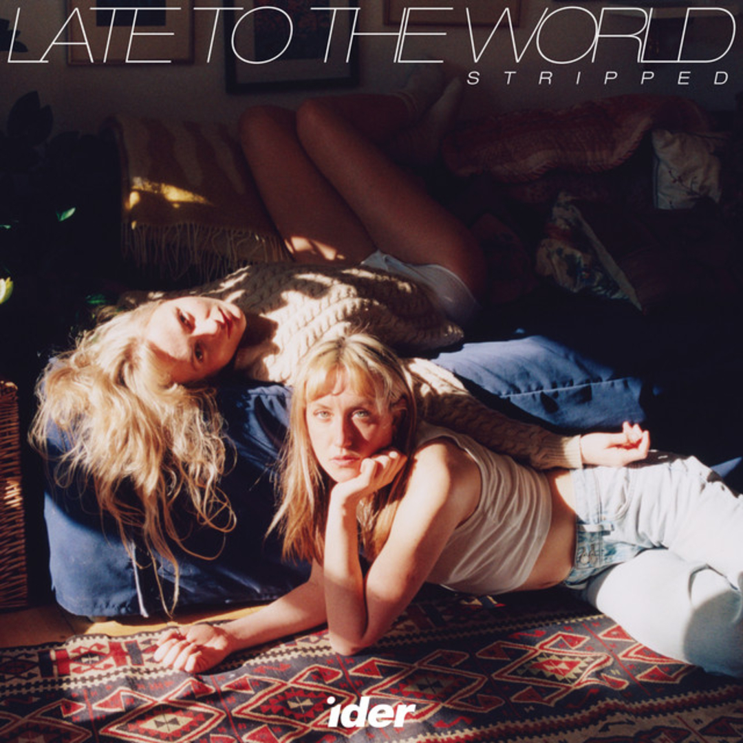 Zwei blonde Frauen liegen im Sonnenlicht auf einem Teppich, melancholisch und intim – das Cover von „Late To The World (Stripped)“ von IDER.