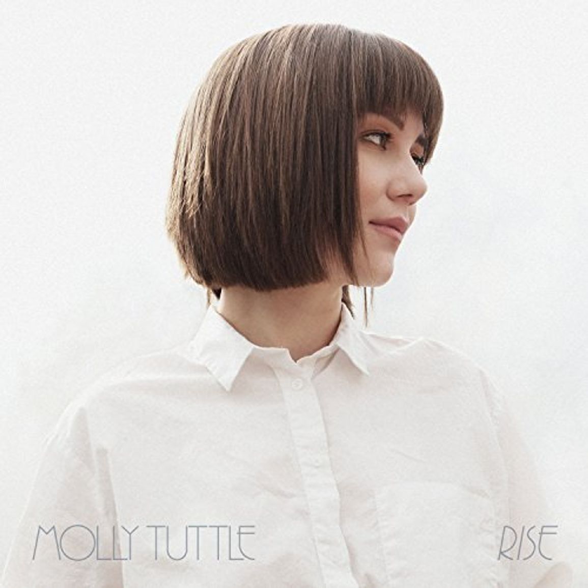Molly Tuttle auf dem Cover von „Rise“ im weißen Hemd, seitlich blickend vor hellem Hintergrund.