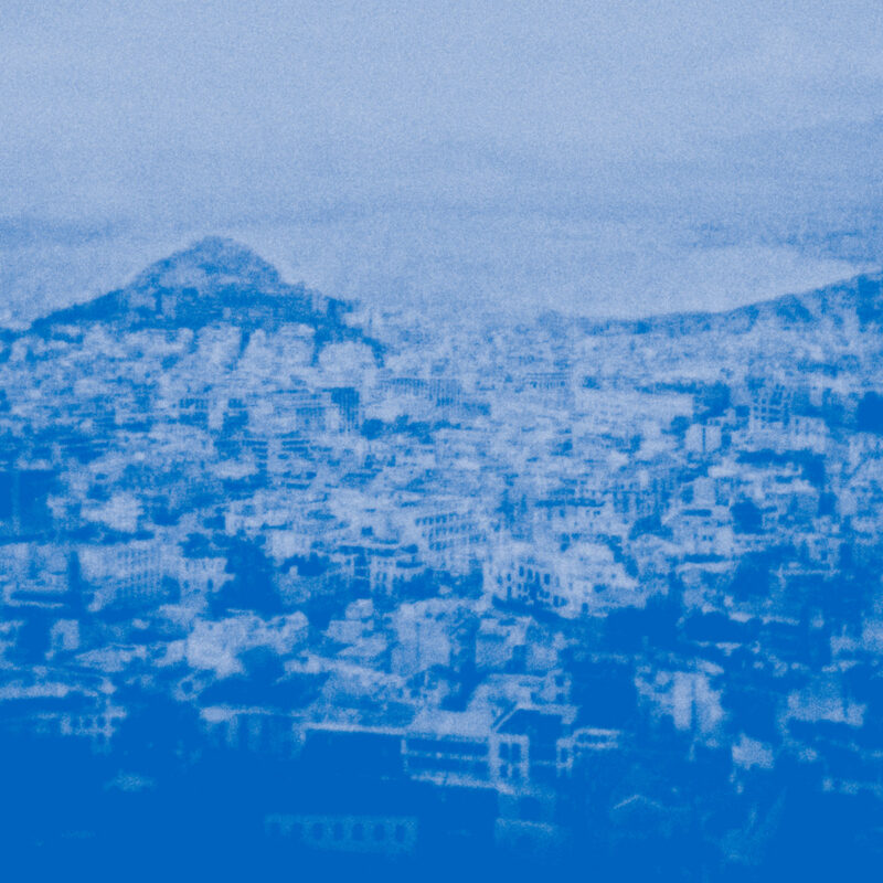 Körniges, monochromes Foto einer griechischen Stadtlandschaft in sattem Blau, abstrahiert als Cover des Albums Syndesis von Madeleine Cocolas.