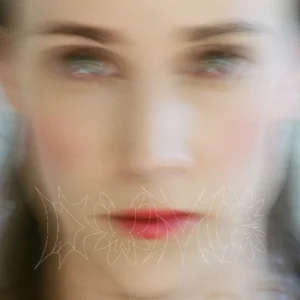 Verschwommenes Albumcover von Emma Louise & Flume – DUMB, ein unscharfes Porträt mit rotem Mund und entrücktem Blick.