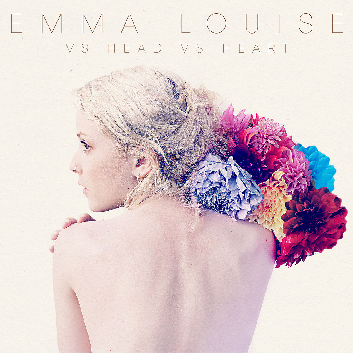Cover von Emma Louise – Vs Head Vs Heart: Porträt mit nackter Schulter, buntes Blumenbouquet im Hintergrund.