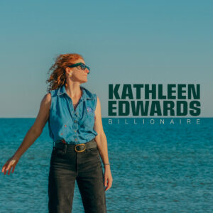 Albumcover von Kathleen Edwards – „Billionaire“: Die Künstlerin steht im Jeanshemd am Meer, mit Sonnenbrille, Blick ins Licht, klare Schriftzüge daneben.