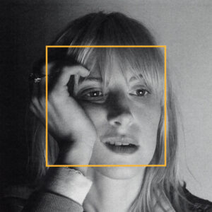 Schwarz-weißes Close-up von Hayley Williams, Blick zur Seite, Hand an der Schläfe, ein gelbes Quadrat markiert das Gesicht wie ein Rahmen, körnige Textur, ruhige Lichtkante.