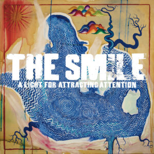Abstraktes Albumcover mit blauer, gezackter Silhouetten-Form auf ockerfarbenem Grund, weißen Großbuchstaben „THE SMILE“, Farbinseln und feinen Linien, malerisch, texturiert.