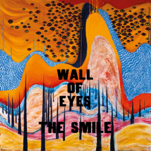 Gemaltes Albumcover mit rostorangefarbenen, gelben und blauen Wellenformen, Schwärmen schwarzer Augen im oberen Drittel, schwarzen, nadelartigen Säulen im Vordergrund, Titel „WALL OF EYES – THE SMILE“ in schwarzer Typo mittig.