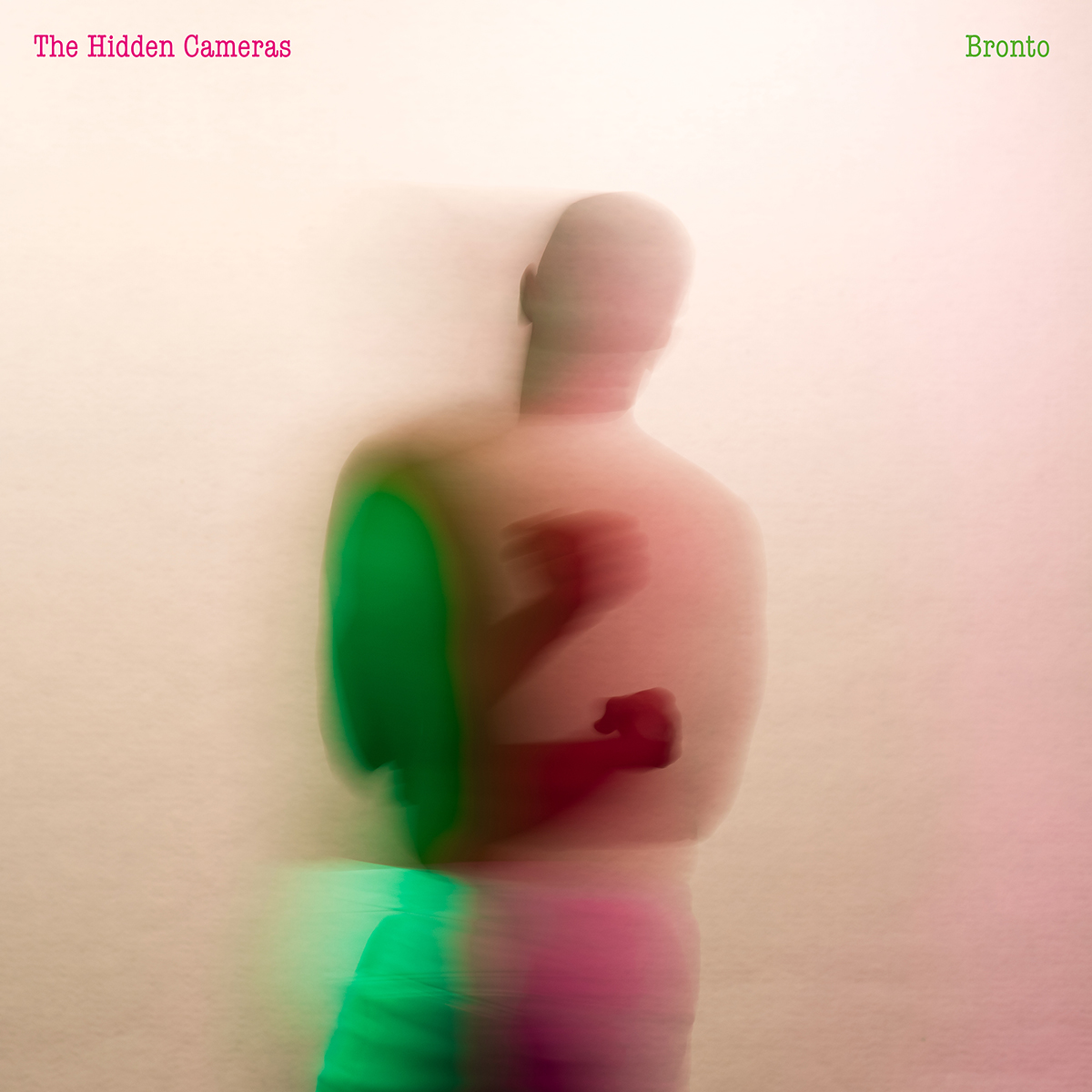 Verschwommenes Albumcover von The Hidden Cameras’ „Bronto“ mit einer in Grün und Rosa schimmernden, tanzenden Silhouette vor hellem Hintergrund.