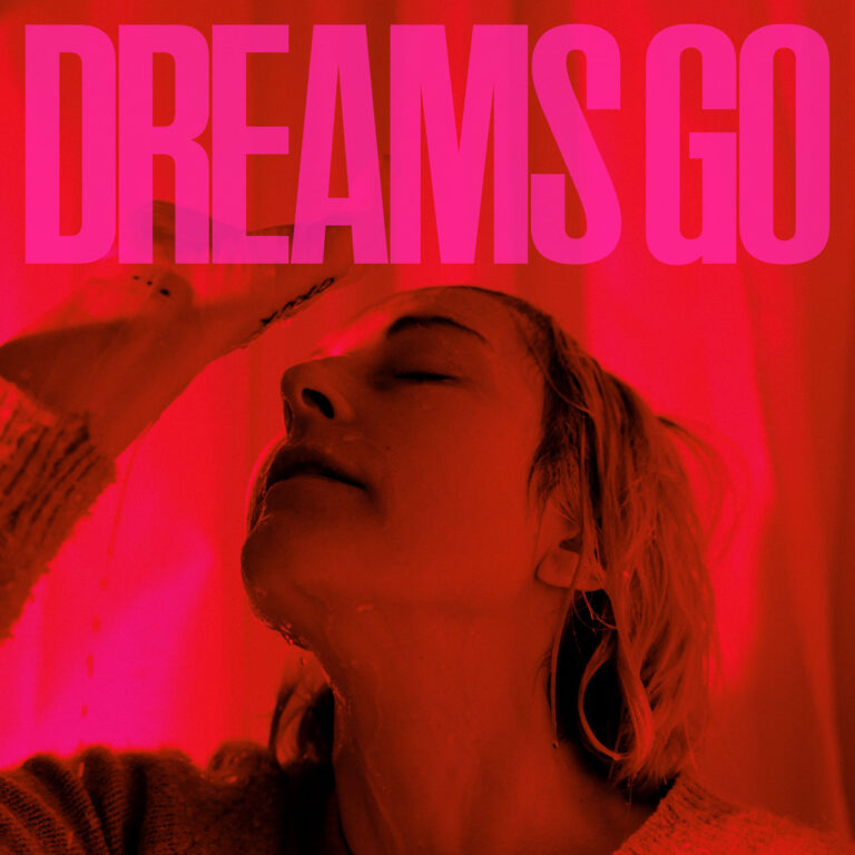 Eine Frau mit nassem Gesicht lehnt den Kopf nach hinten, überflutet von rotem Licht, über ihr prangt in Großbuchstaben der Titel „DREAMS GO“ – ein intensives, emotionales Albumcover voller innerer Spannung.