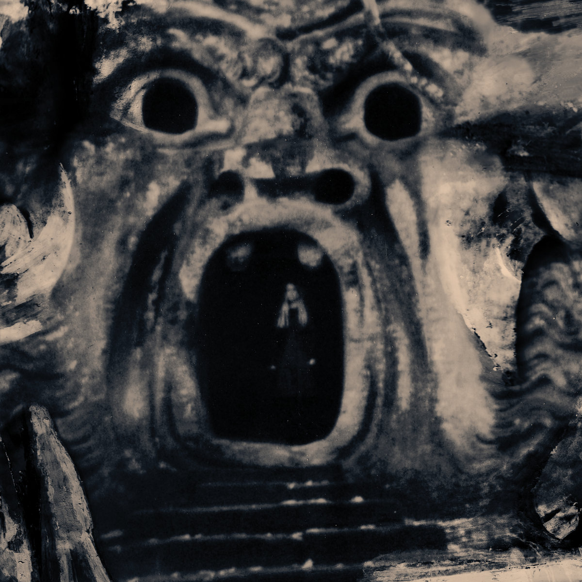 Eine Frau steht im dunklen Inneren eines steinernen Monsters mit weit geöffnetem Maul, das wie ein Eingang in eine andere Welt wirkt. Schwarzweiß gehalten, bedrohlich und mystisch.