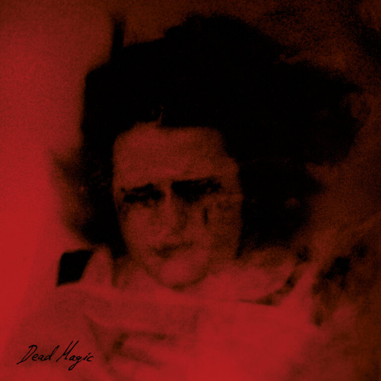 Verschwommenes, rötlich getauchtes Porträt einer Frau mit dunklem Haar und angedeutetem Gesichtsausdruck, umhüllt von Schatten und Unschärfe, Schriftzug „Dead Magic“ unten links.