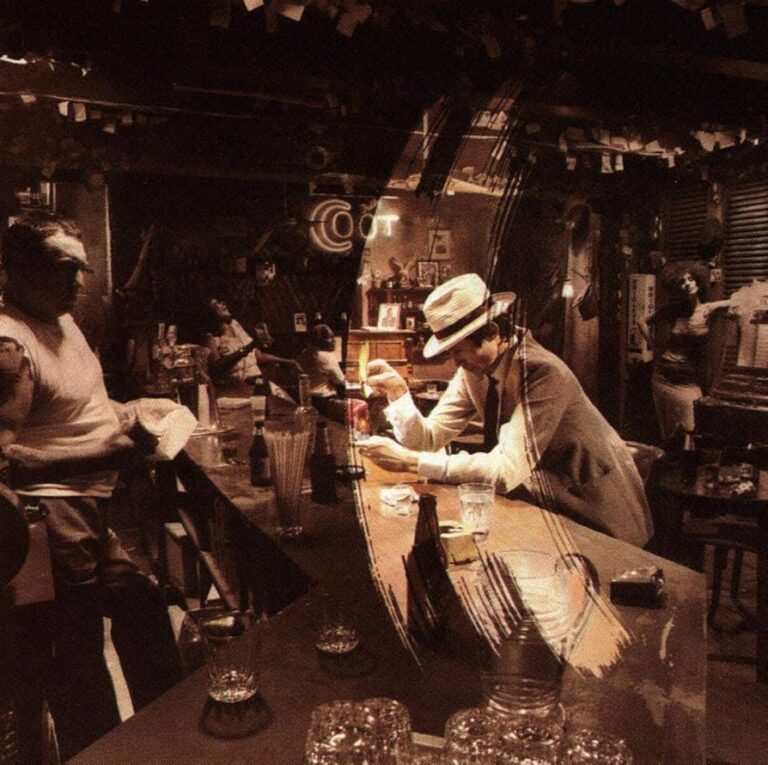 Sepiafarbenes Albumcover in einer Bar: ein Mann mit Hut sitzt am Tresen und verbrennt einen Brief, umgeben von mehreren Gästen, die ihn aus unterschiedlichen Richtungen beobachten.