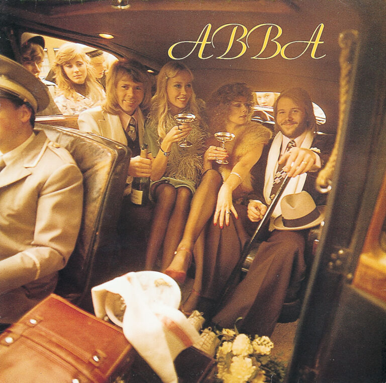 Vier Mitglieder von ABBA sitzen in einer offenstehenden Limousine, halten Sektgläser, tragen elegante Kleidung und posieren in hellem Studiolicht, während ein Chauffeur im Vordergrund sichtbar ist.