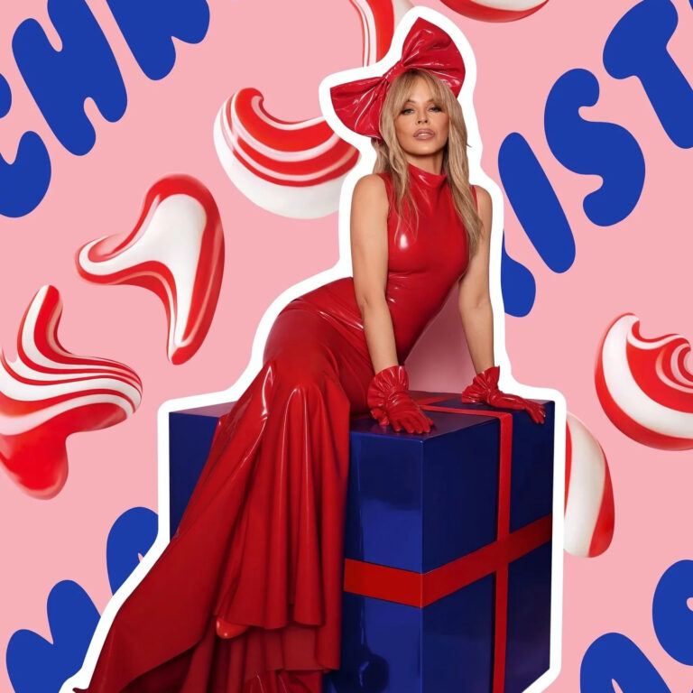 Kylie Minogue sitzt in einem langen roten Latexkleid mit übergroßer Schleife auf einem blauen Geschenkpaket vor pinkem Hintergrund mit rotweißen Ornamenten.
