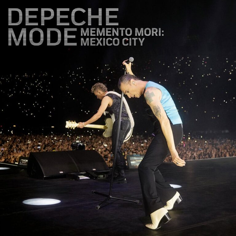 Depeche Mode live auf der Bühne in Mexiko City, Dave Gahan im Vordergrund im Scheinwerferlicht, dunkle Stadionkulisse, konzentrierte Atmosphäre.