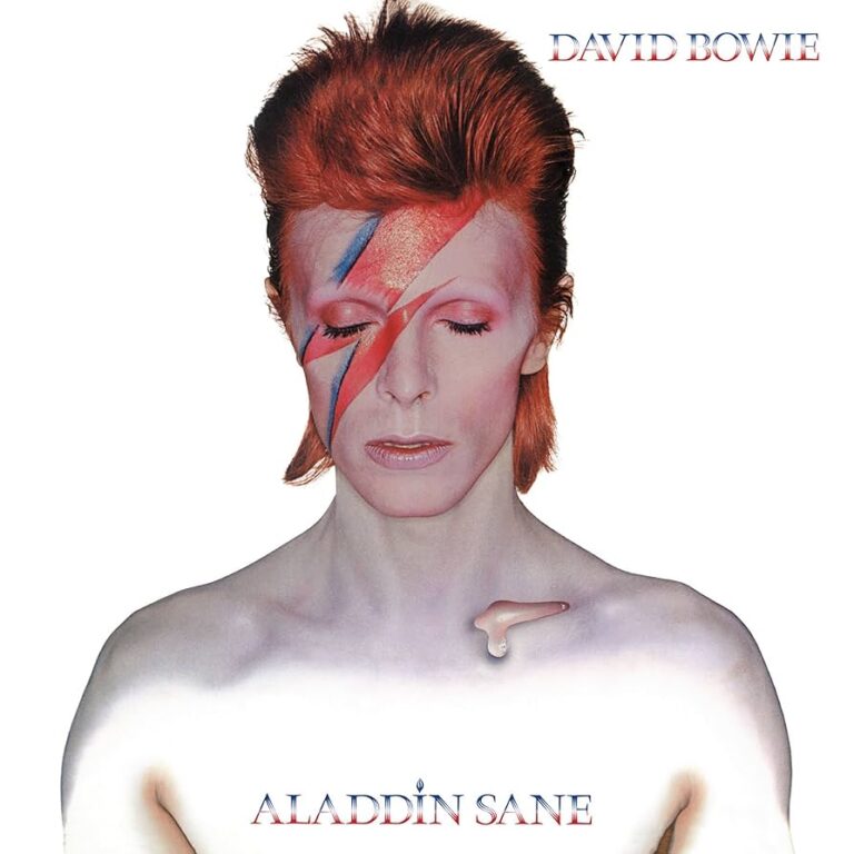 Porträt von David Bowie mit rotem Haar, weiß geschminktem Oberkörper und einem rot blauen Blitz, der sein Gesicht diagonal teilt, vor hellem Hintergrund.