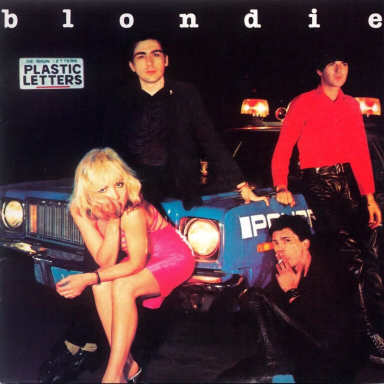 Blondie Albumcover „Plastic Letters“ mit nächtlicher Straßenszene vor einem Auto, grelle Scheinwerfer, dunkler Hintergrund, Debbie Harry im pinken Kleid, Bandmitglieder in Schwarz und Rot.