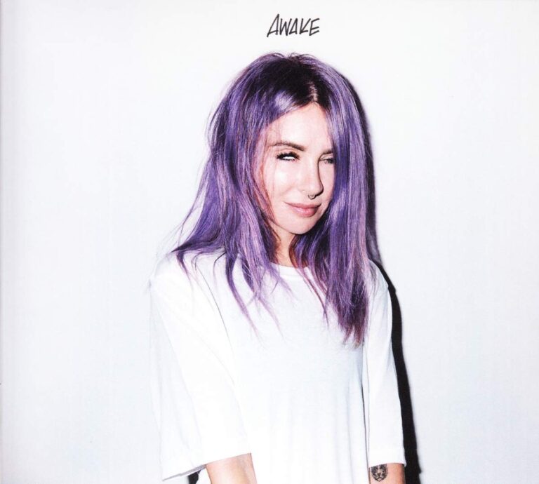 Porträt von Alison Wonderland vor hellem Hintergrund, mit pastelllila Haaren und weißem Shirt, direkter Blick in die Kamera, reduziertes und intimes Albumcover.