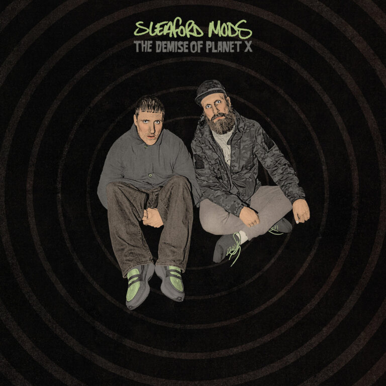 Sleaford Mods sitzen frontal vor dunklem Hintergrund, stilisiert und künstlich inszeniert, mit dem Albumtitel „The Demise of Planet X“ darüber.