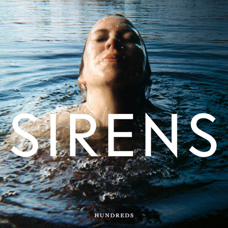 Albumcover von „Sirens“ zeigt eine im Wasser liegende Figur mit geschlossenen Augen, kühl ausgeleuchtet vor dunklem Hintergrund.
