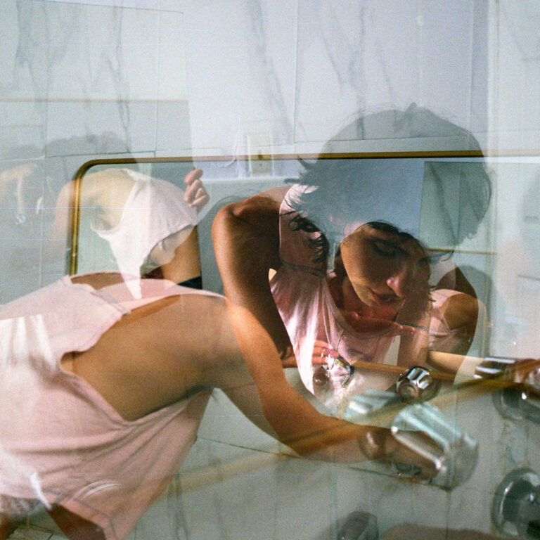 Das Albumcover zeigt eine Mehrfachbelichtung von Camila Ortiz in einem Badezimmer. Ihr Körper und Gesicht erscheinen transparent und überlappend, während sie sich über ein weißes Waschbecken beugt. Die Farbtöne sind gedämpft und wirken durch das Filmmaterial körnig und atmosphärisch.