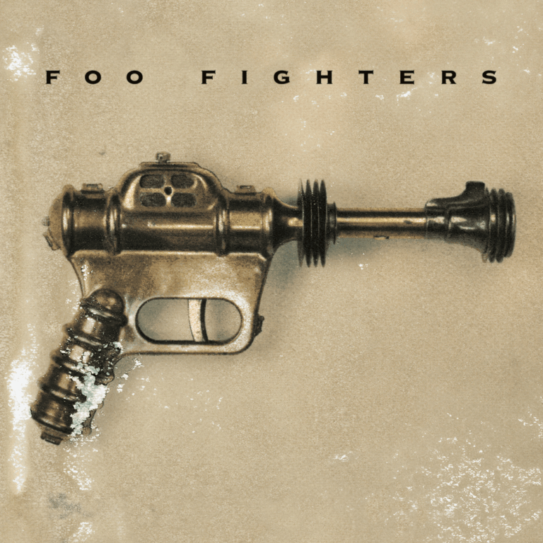 Das Albumcover der Foo Fighters zeigt eine antike, bronzefarbene Spielzeug-Strahlenpistole vor einem schlichten, beigen Hintergrund. Am oberen Rand steht in klarer, schwarzer Blockschrift der Bandname.