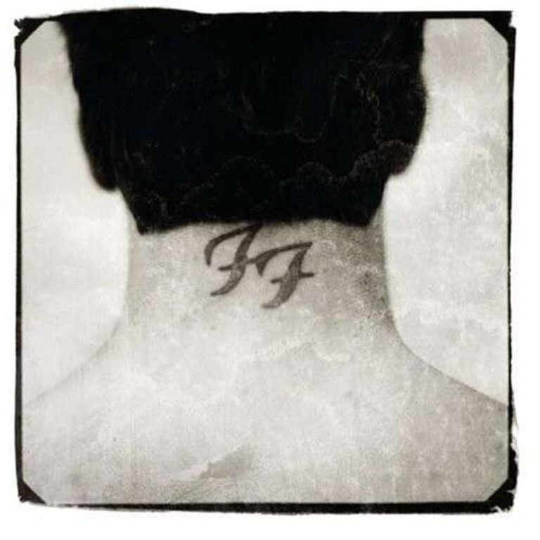 Eine Schwarz-Weiß-Fotografie zeigt den Nacken einer Person mit kurzen dunklen Haaren, auf dem das Logo der Foo Fighters als Tattoo zu sehen ist.