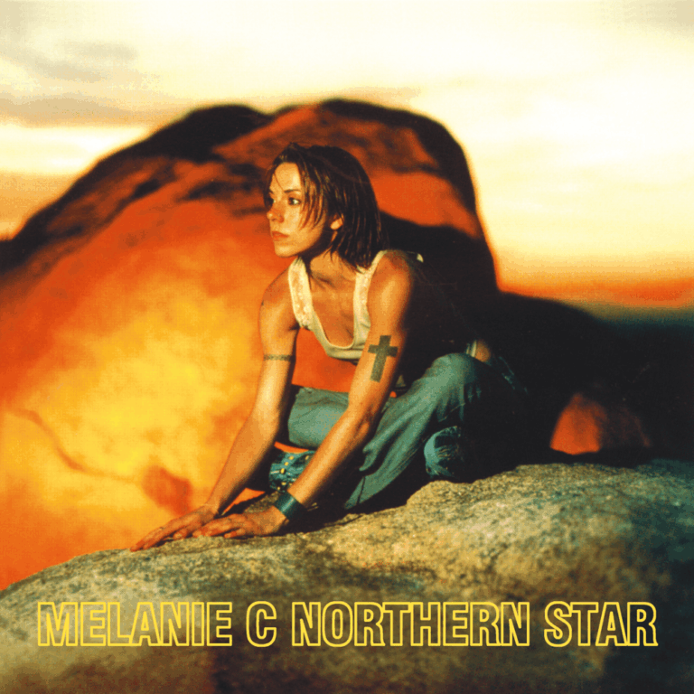 Das quadratische Albumcover zeigt Melanie C in einer kauernden Pose auf einem hellen Felsen vor einer glutroten, unscharfen Hintergrundlandschaft, die an eine Wüste bei Sonnenuntergang erinnert. Sie trägt ein helles, ärmelloses Top und weite Jeans, ihr Blick ist nachdenklich zur Seite gerichtet; am unteren Rand steht in gelber Konturschrift ihr Name und der Albumtitel.