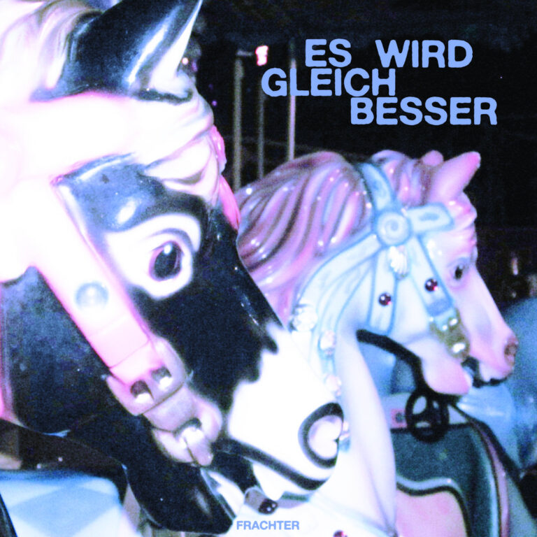 Nahaufnahme zweier Karussellpferde in stark übersättigten Blau- und Pinktönen unter nächtlichem Licht, darüber der Schriftzug „ES WIRD GLEICH BESSER“ in serifenloser, blauer Typografie.