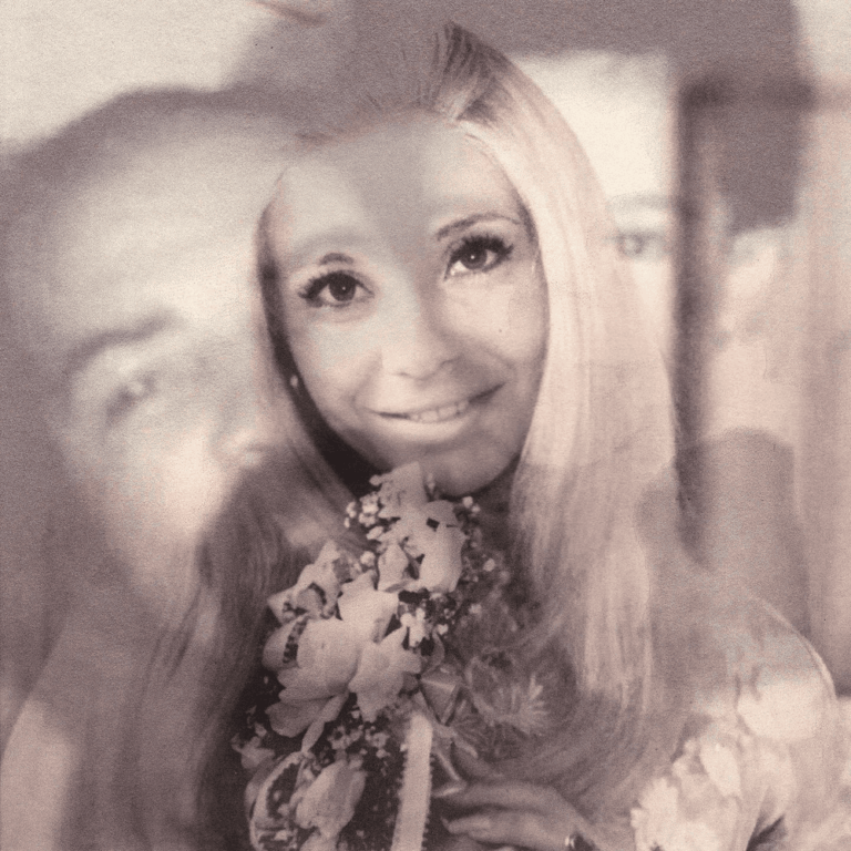 Eine Sepia-Doppelbelichtung zeigt eine lächelnde Frau mit Blumen und ein schemenhaftes Männergesicht im Hintergrund.