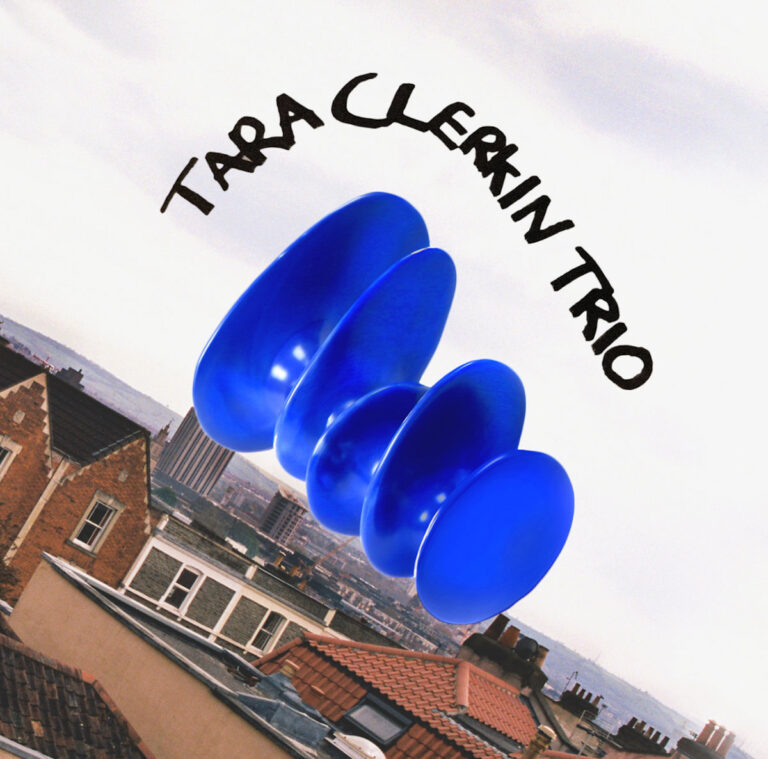 Eine abstrakte, glänzende blaue Skulptur schwebt am Himmel über europäischen Hausdächern.
