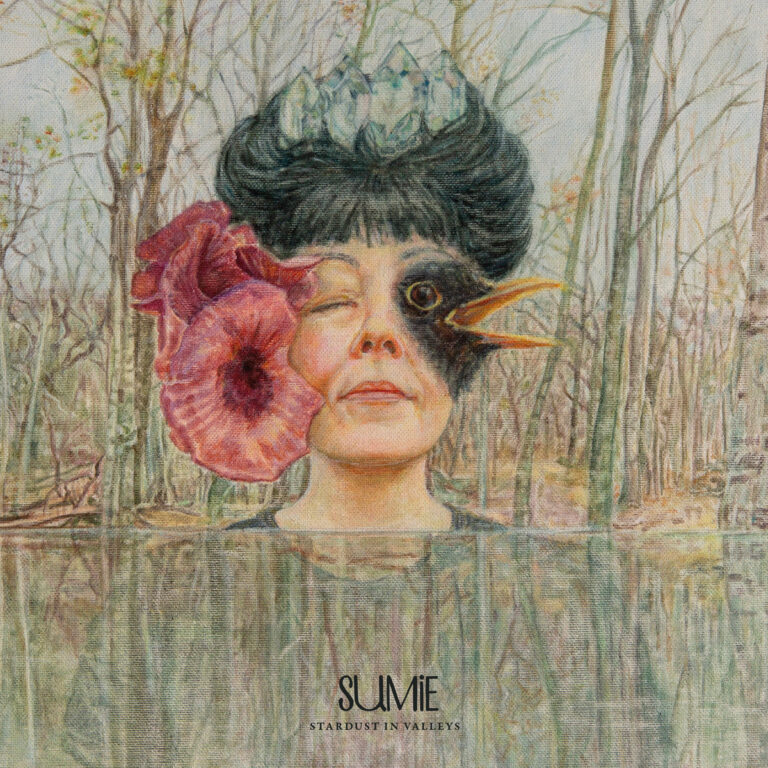 Eine Frau mit Blumen im Haar und einer Vogelmaske am Auge steht im Wald.