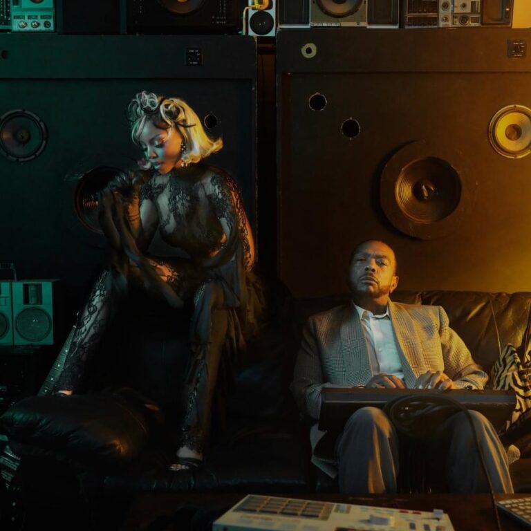 Chlöe und Timbaland sitzen in einem dunkel beleuchteten Studio vor einer Wand aus Lautsprechern.