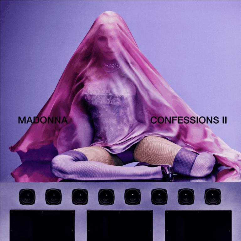 Madonna sitzt unter einem transparenten rosa Schleier auf einer spiegelnden Metalloberfläche.