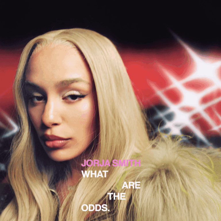 Nahaufnahme von Jorja Smith mit blonder Perücke und Pelz vor rot-schwarzem Hintergrund.