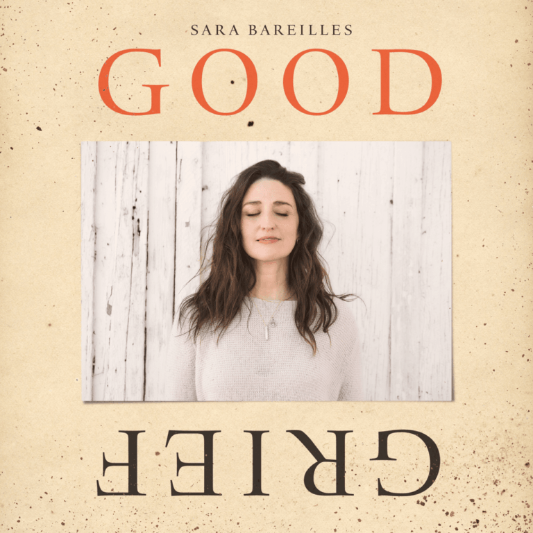 Sara Bareilles steht mit geschlossenen Augen vor einer hellen Holzverkleidung.