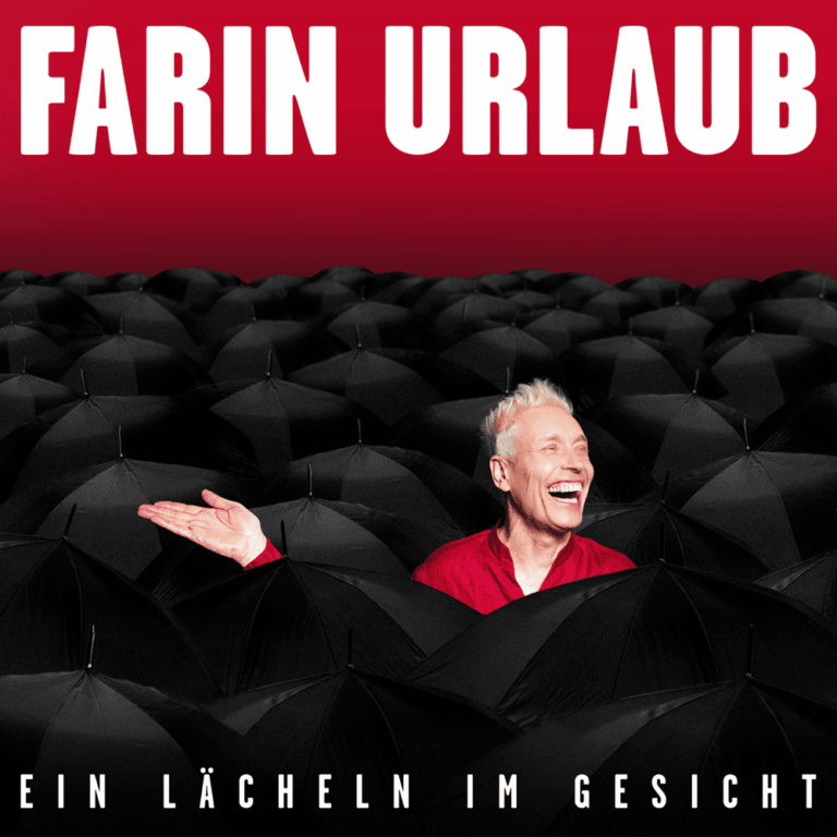Ein lächelnder Mann ragt aus einer Masse geöffneter schwarzer Regenschirme heraus.