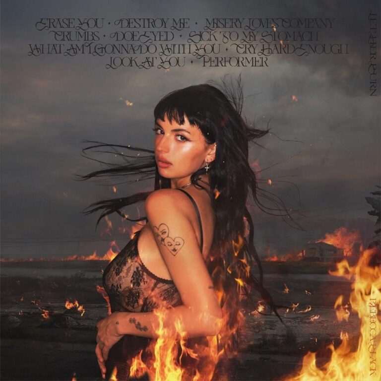 Rebecca Black blickt vor lodernden Flammen über ihre Schulter.