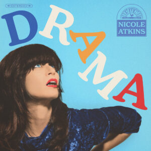 Nicole Atkins blickt auf einem hellblauen Hintergrund aufwärts, gerahmt von bunt geschwungenen Buchstaben des Albumtitels.