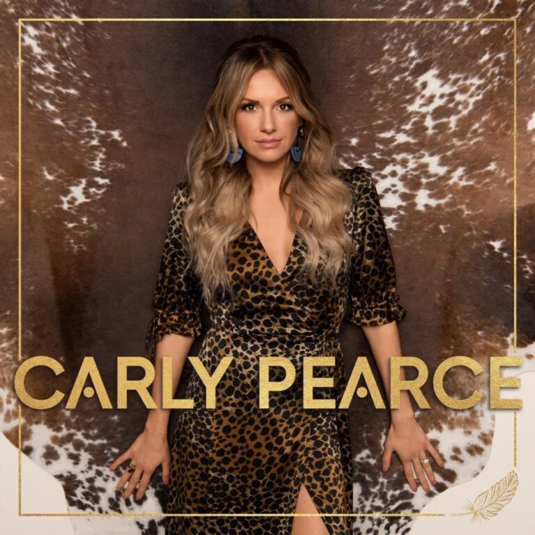 Sängerin Carly Pearce posiert in einem gemusterten Kleid vor dunklem Hintergrund innerhalb eines goldenen Rahmens.